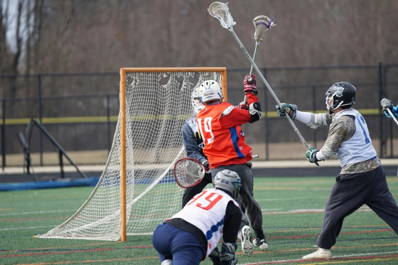 lacrosse players playing an indoor sport on grass