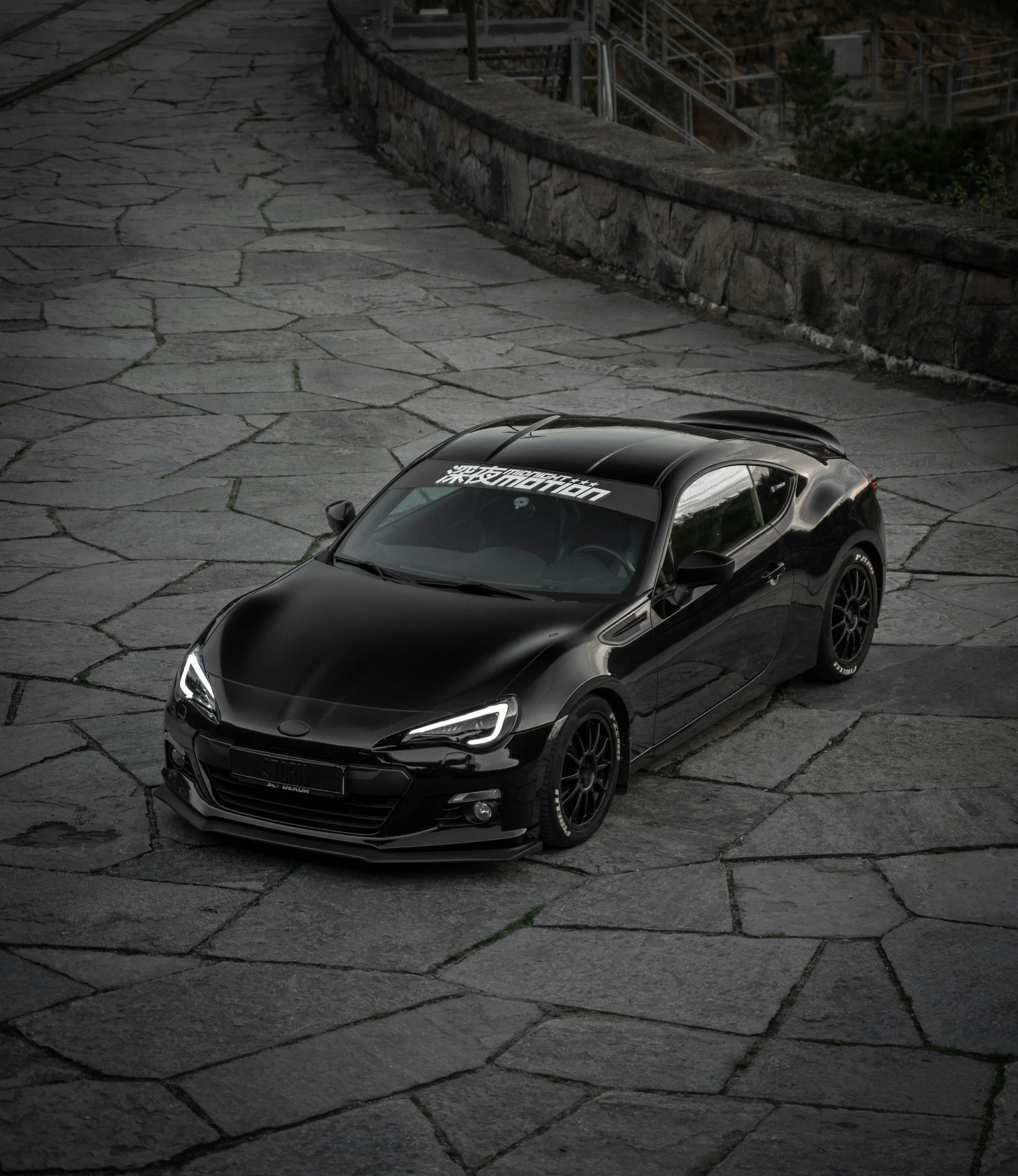 a black sports car parked on a wet lot