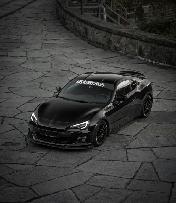 a black sports car parked on a wet lot