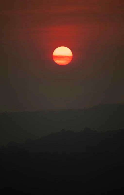 the sun sets over mountains and valleys as it sets