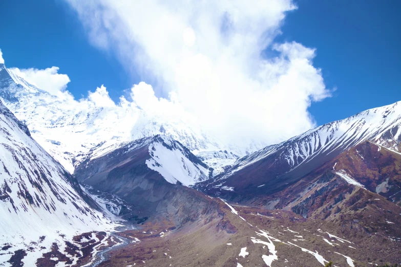 some snow mountains are seen on a sunny day