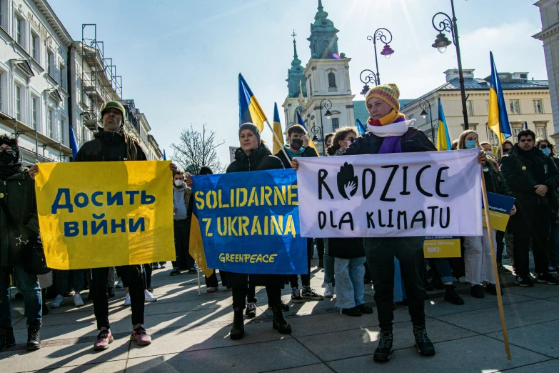 some people holding up signs and standing in the street