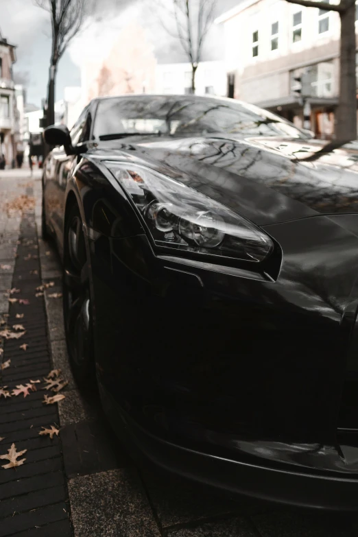 there is a black sports car parked next to a curb