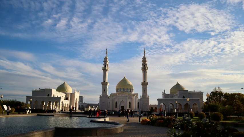 people standing in front of a building with two towers and several spires