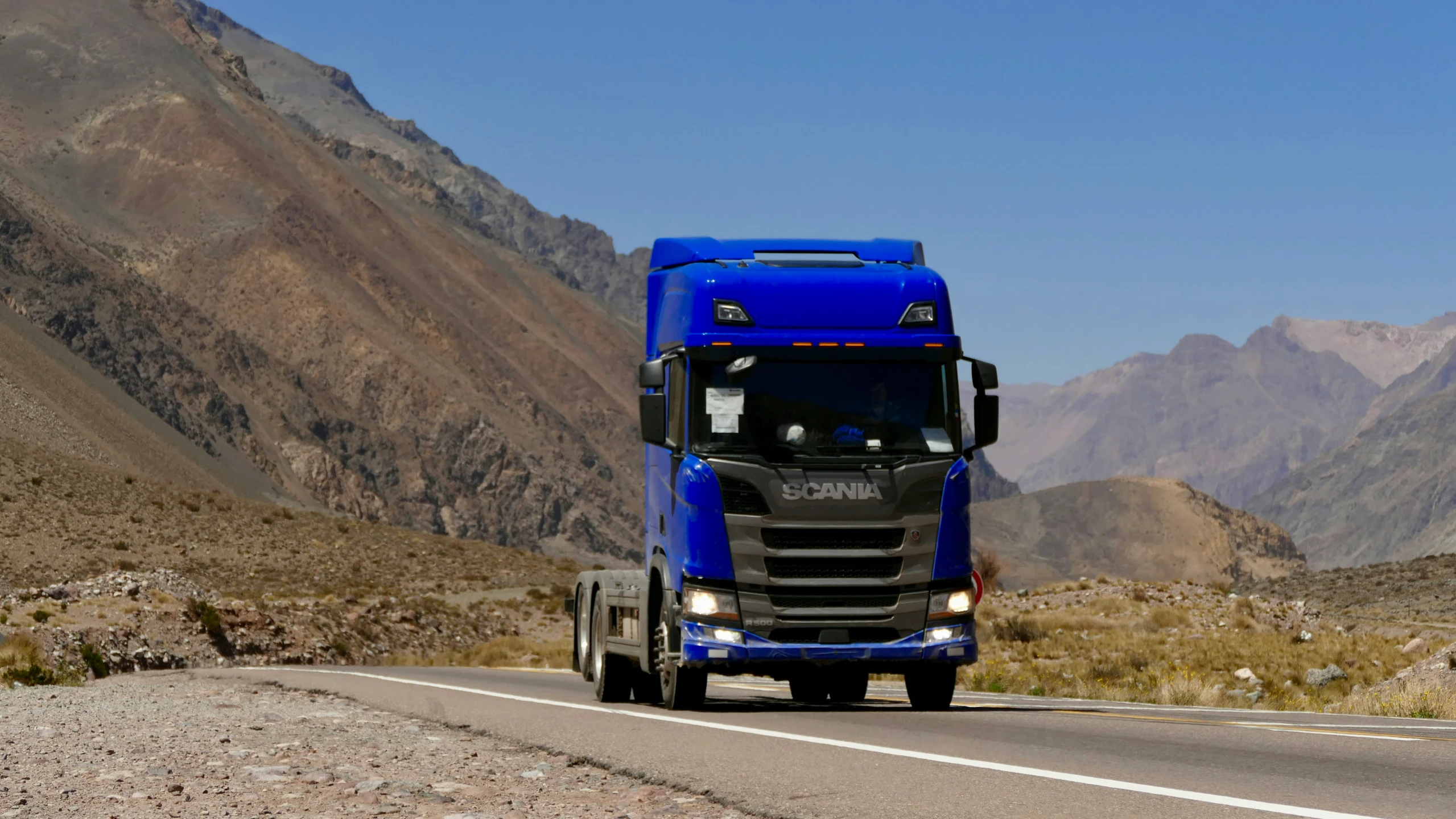 a large blue truck on a paved road