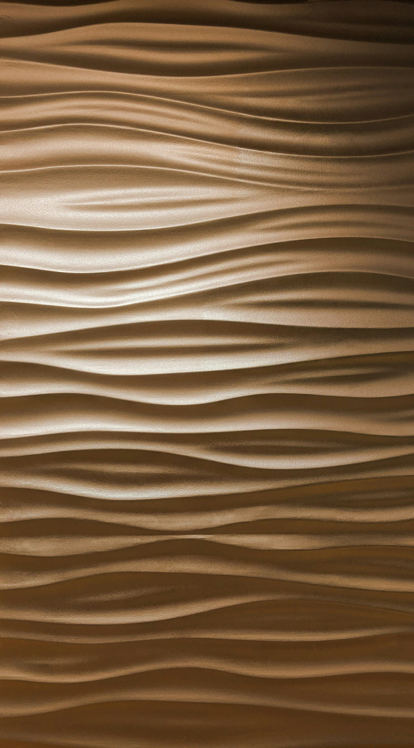 a large brown sand dune with very small waves