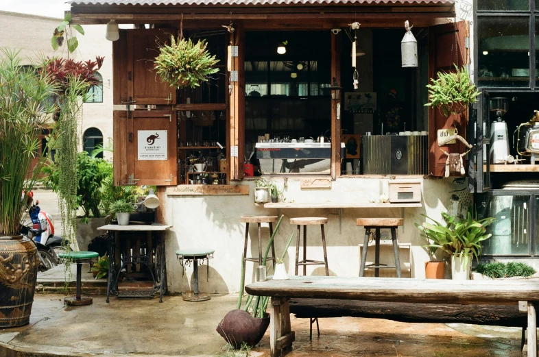 a restaurant with wood tables outside sitting on concrete