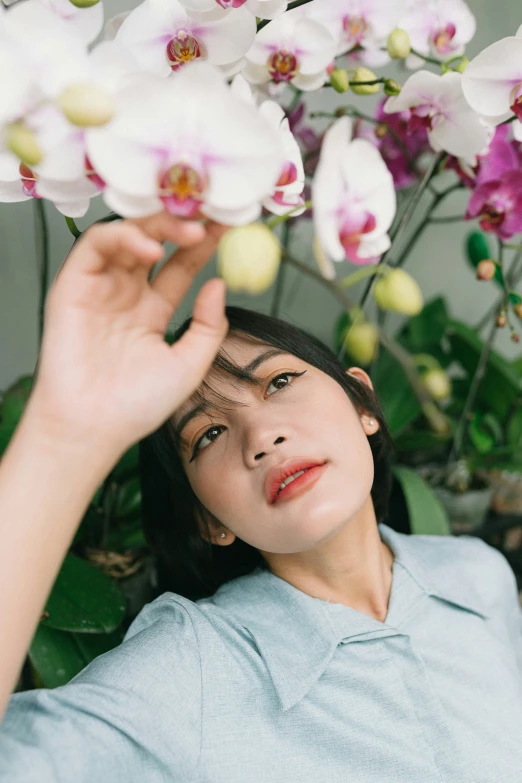 a woman looks up at white flowers in her hand