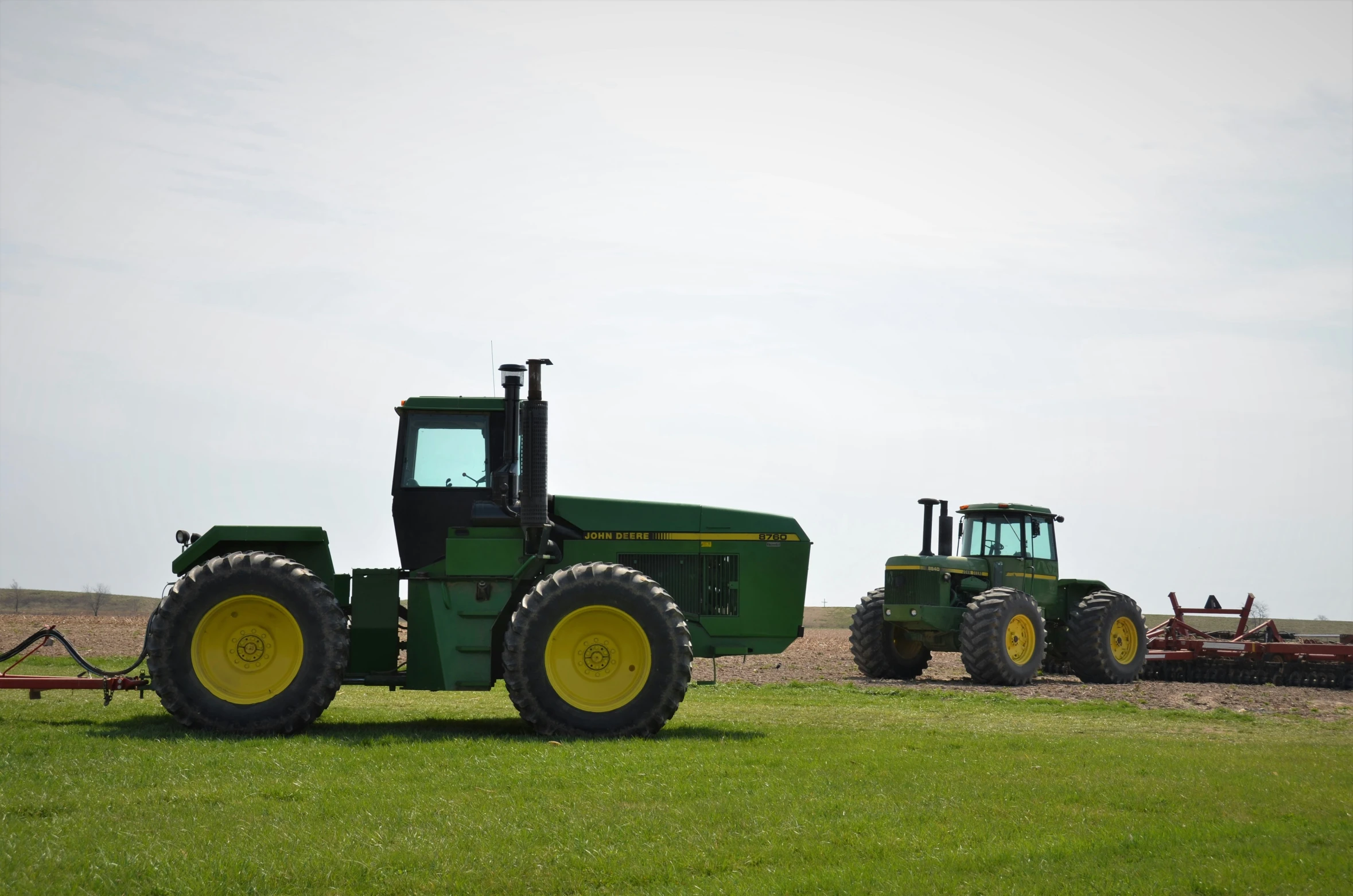 tractor trailers on a field with a man riding it