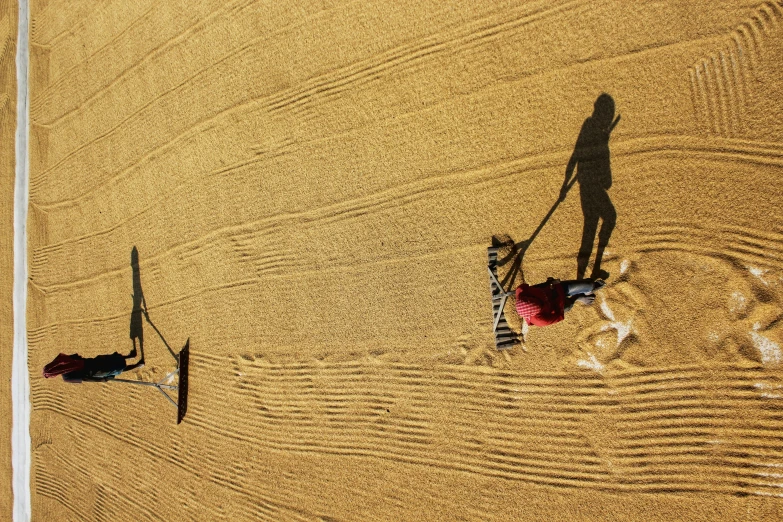 two people in the sand with a kite