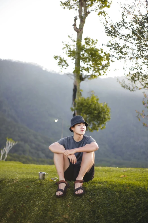 a man kneeling on top of a lush green field