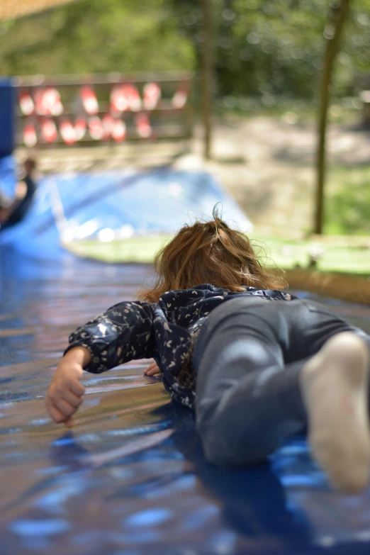a small child is playing on an inflatable water slide