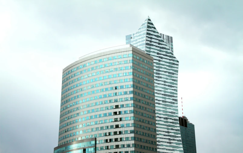 a tall building with many windows with a red traffic signal in the middle