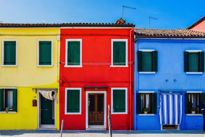 a row of houses with colorful windows and shutters