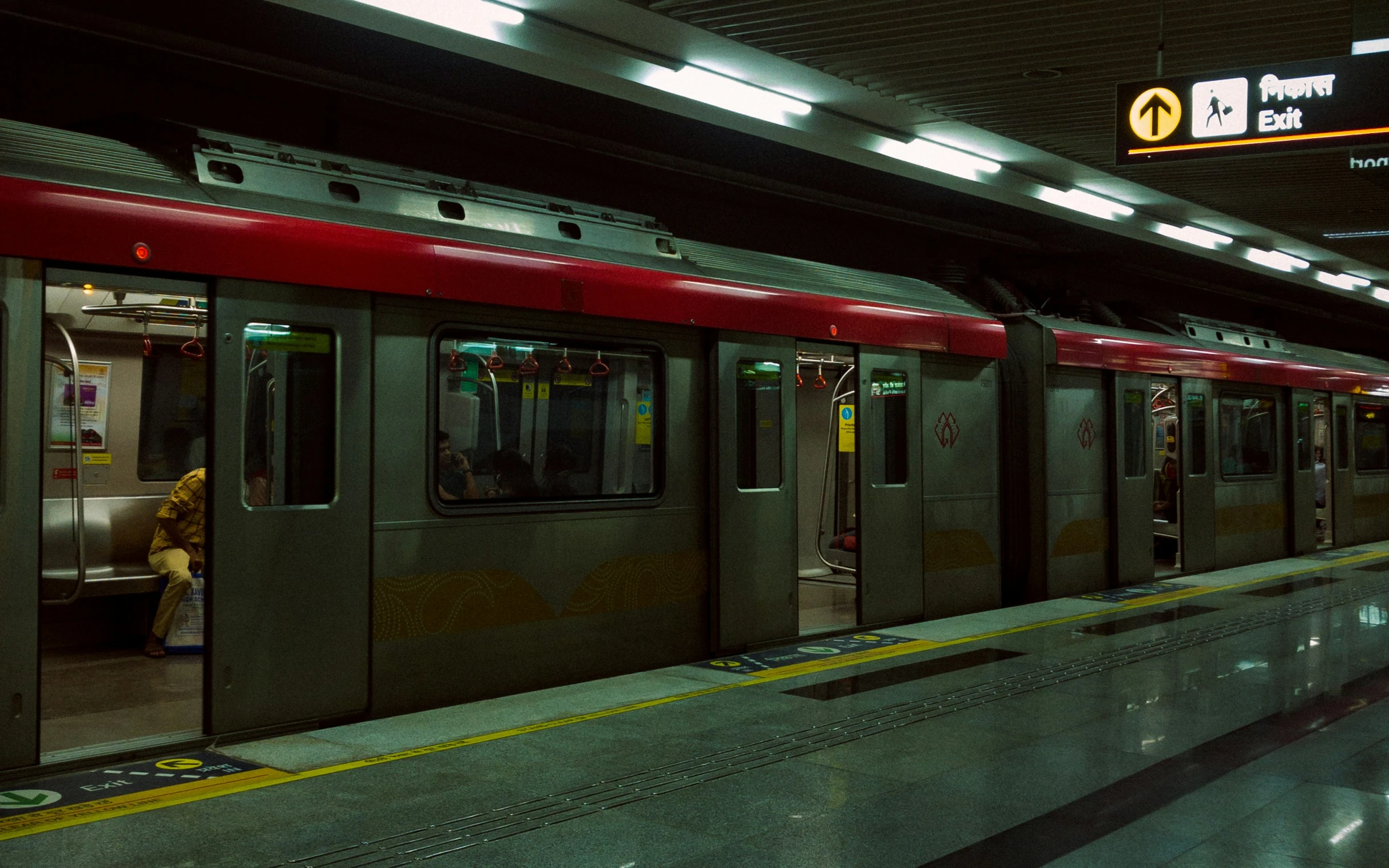 an empty train in a subway station with people standing