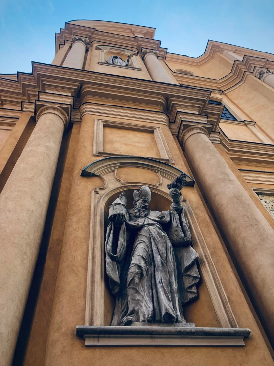 a large tan building with an elaborate statue on it's front