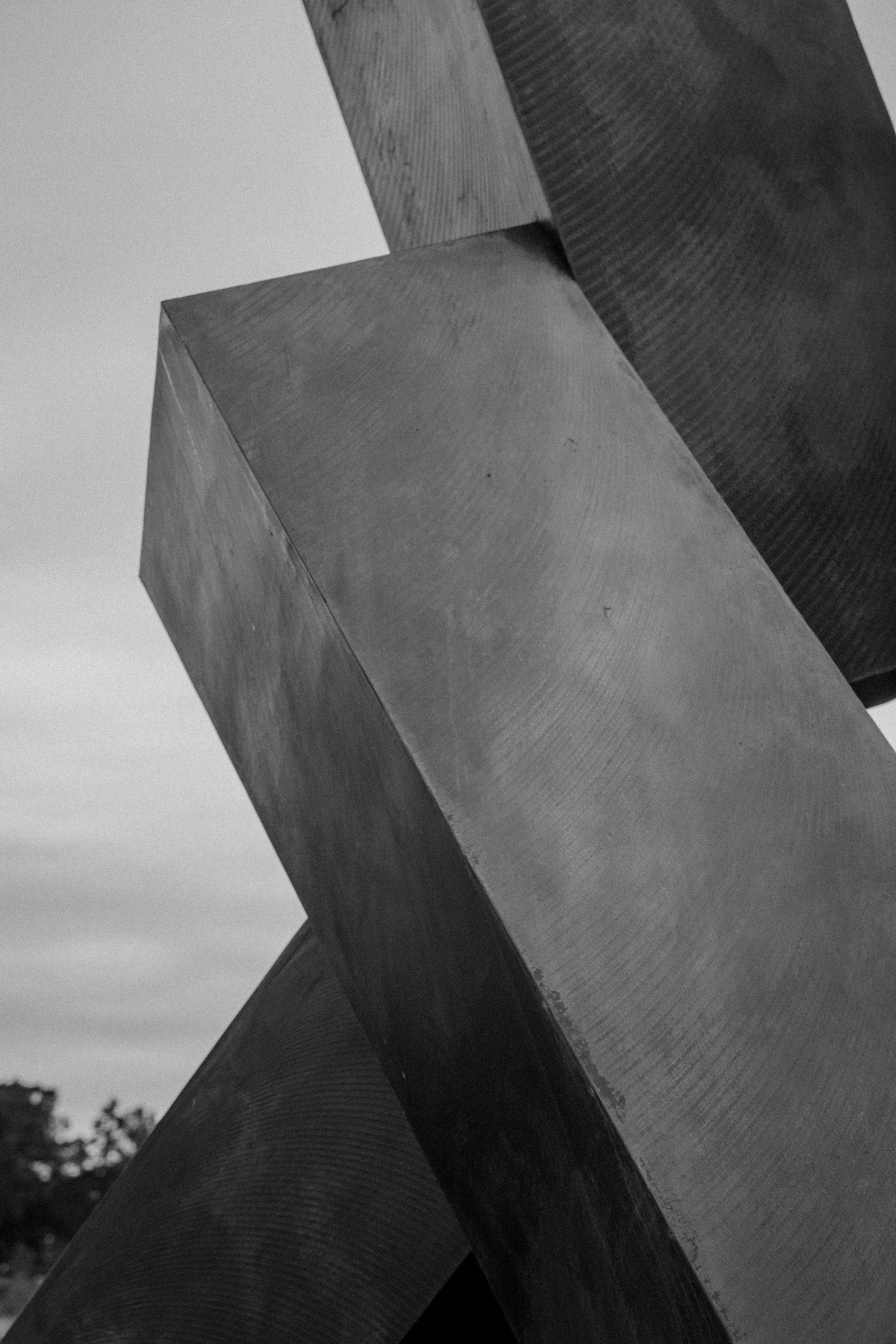 a large metal sculpture sitting next to a building