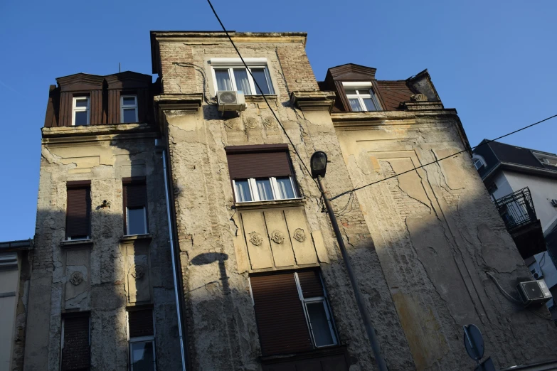 the facade of an old building with three balconies and four open shutters