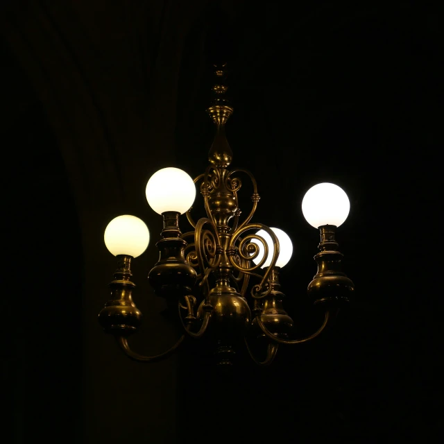 a fancy chandelier glowing from within the darkness