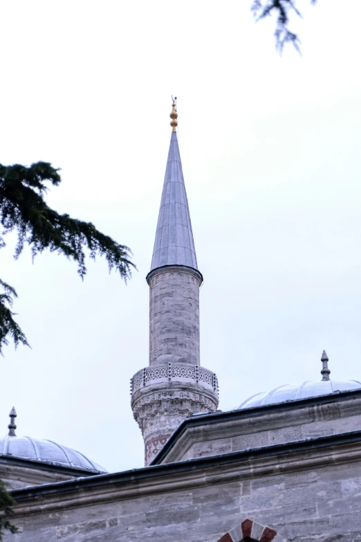 an ornate, circular tower stands behind a larger structure