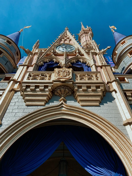 the castle is very ornate and blue and there is also a clock tower