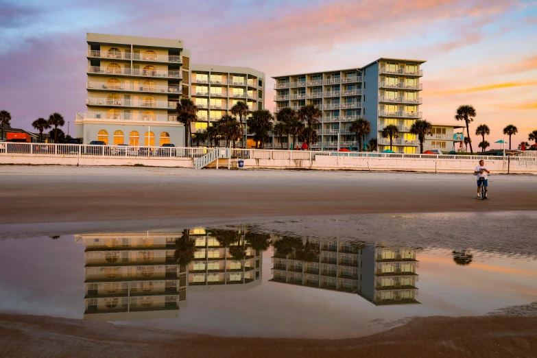 a tall multi story building next to beach