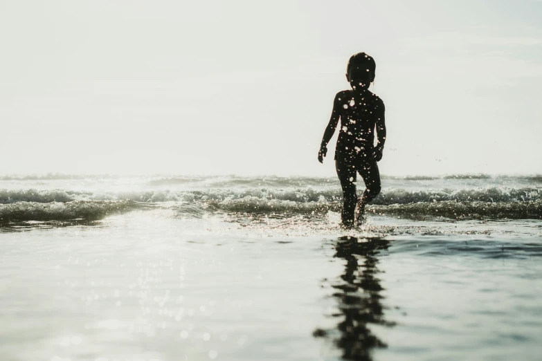 a person standing on the beach in front of a body of water