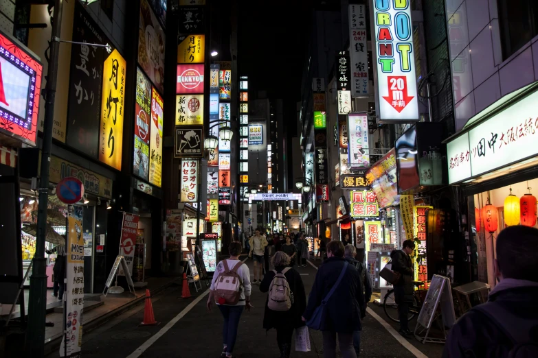 the street at night with people and neon signs