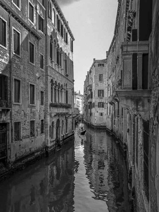 a narrow canal surrounded by brick buildings near a light house