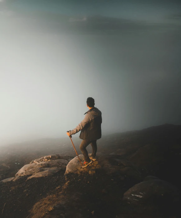 a hiker stands on the edge of a steep mountain