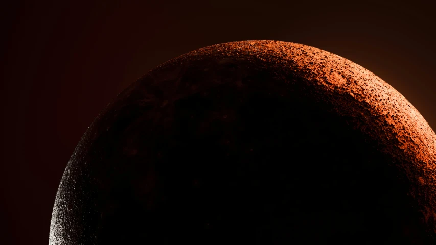 a very dark picture of the moon against a red background