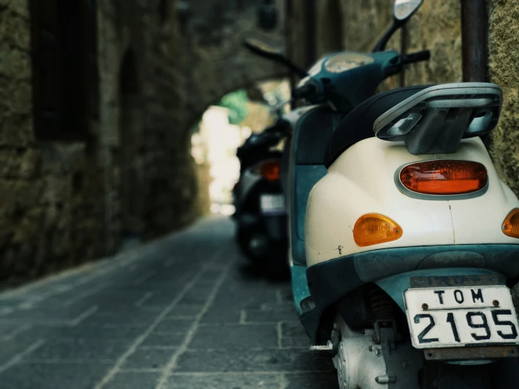 an old scooter is shown parked on a narrow street