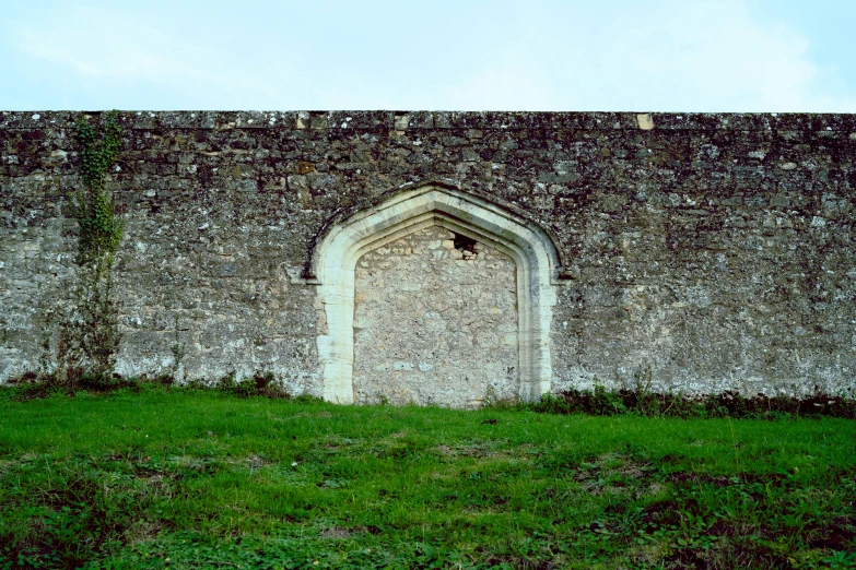 an old stone wall with a window between it