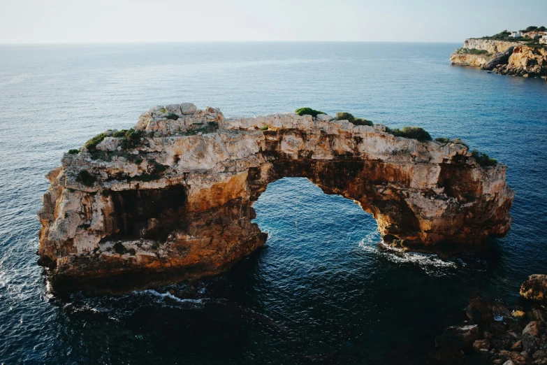 a rock bridge in the middle of the ocean