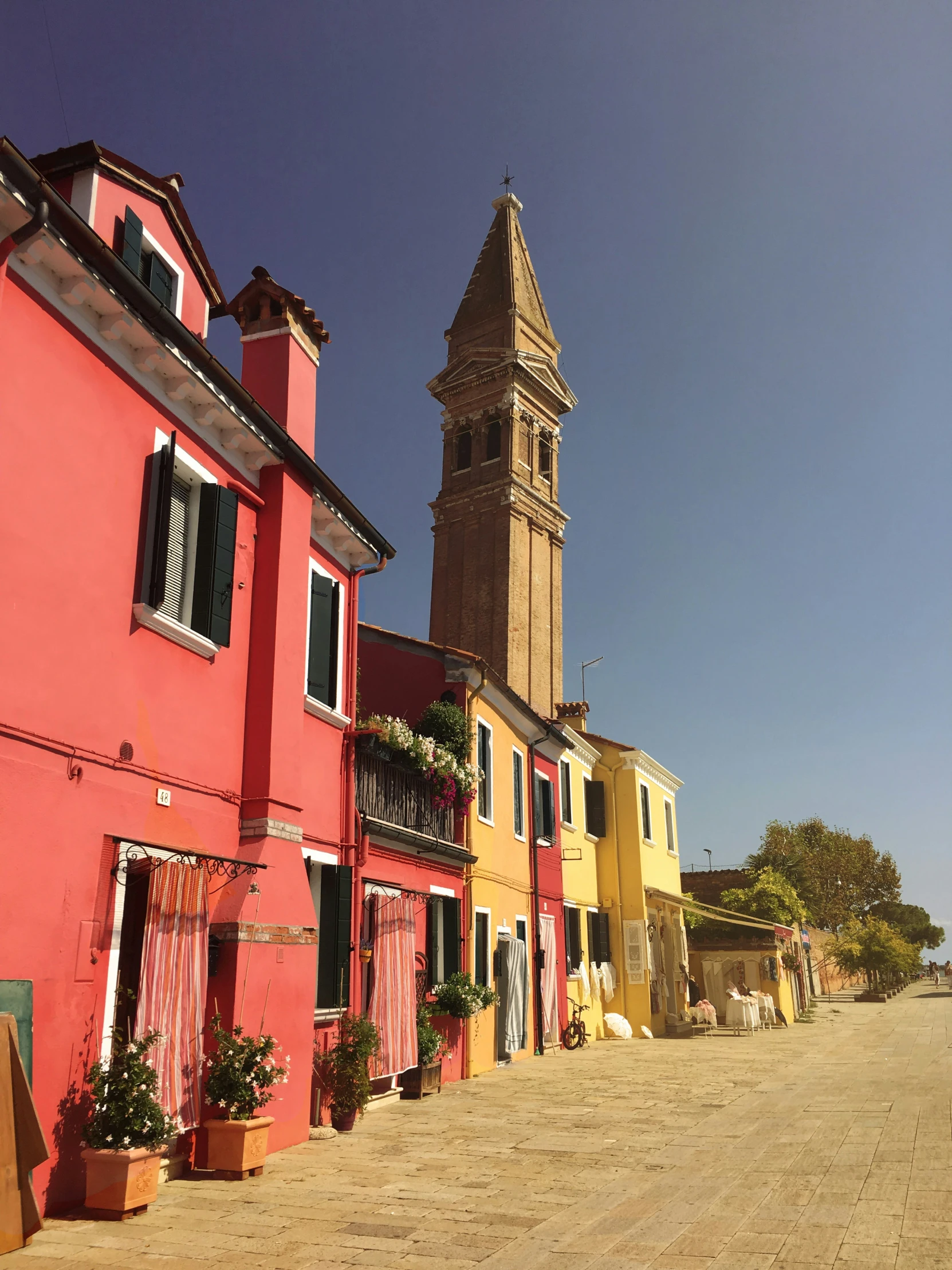 some houses are lined up in front of a tall tower