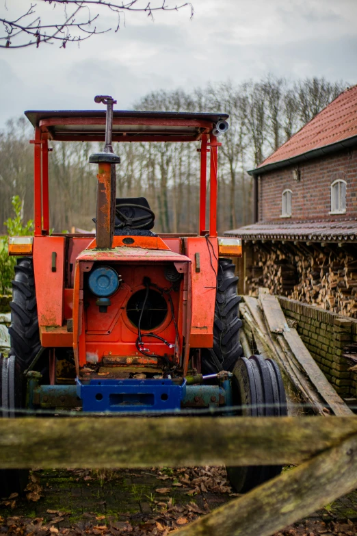 a tractor parked outside a small building in the woods