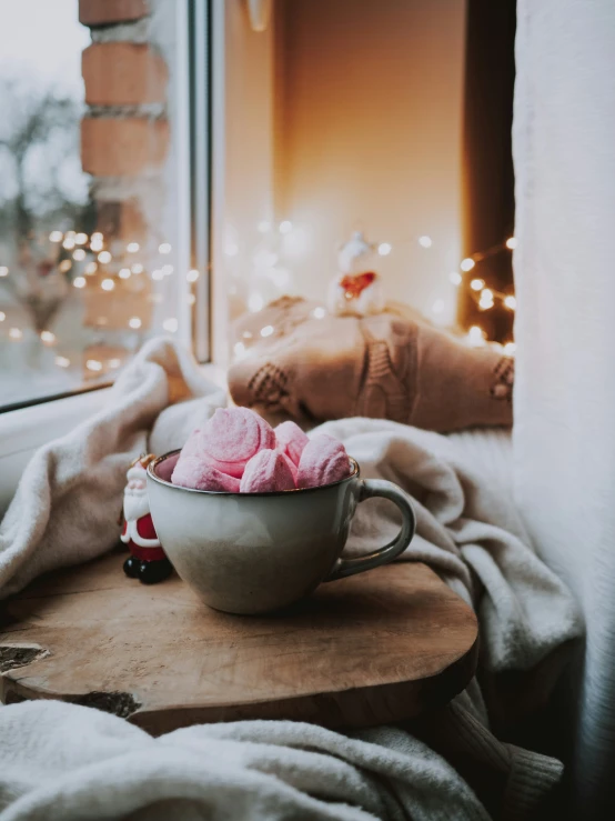 a cup filled with pink food on top of a wooden table