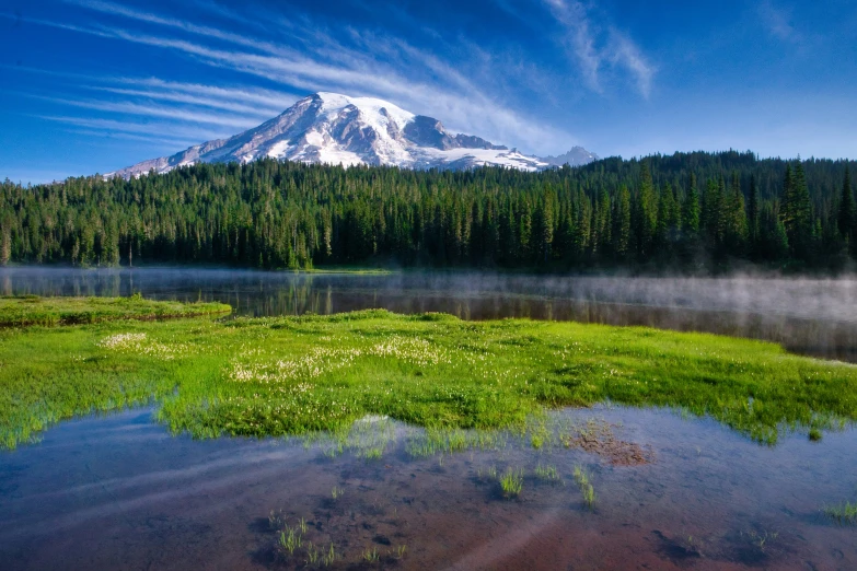 a mountain towering over a lake in the distance