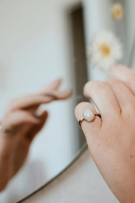 a close up of a person wearing a ring holding a cell phone