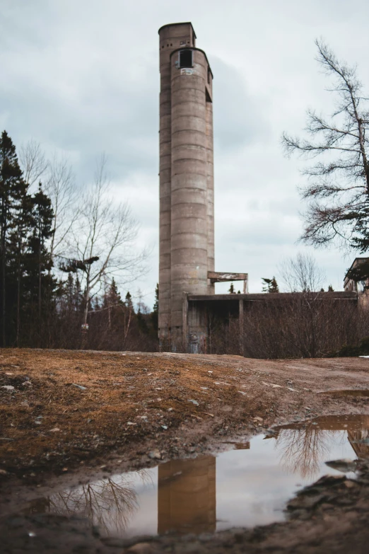 an old water tower with a reflection on the dle