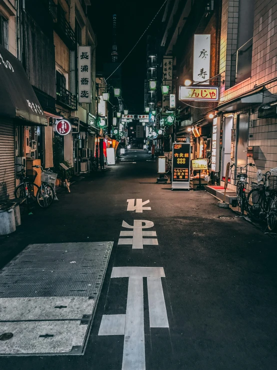 an empty street at night with signage on the sides