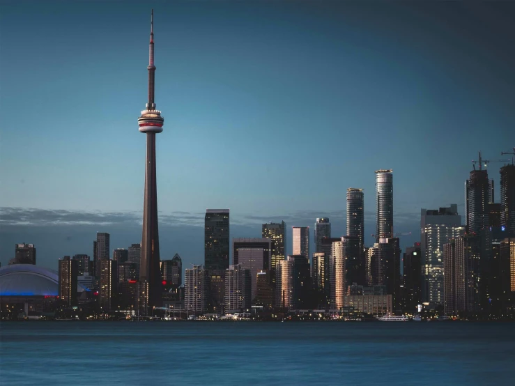 a large city with tall buildings in front of a blue ocean