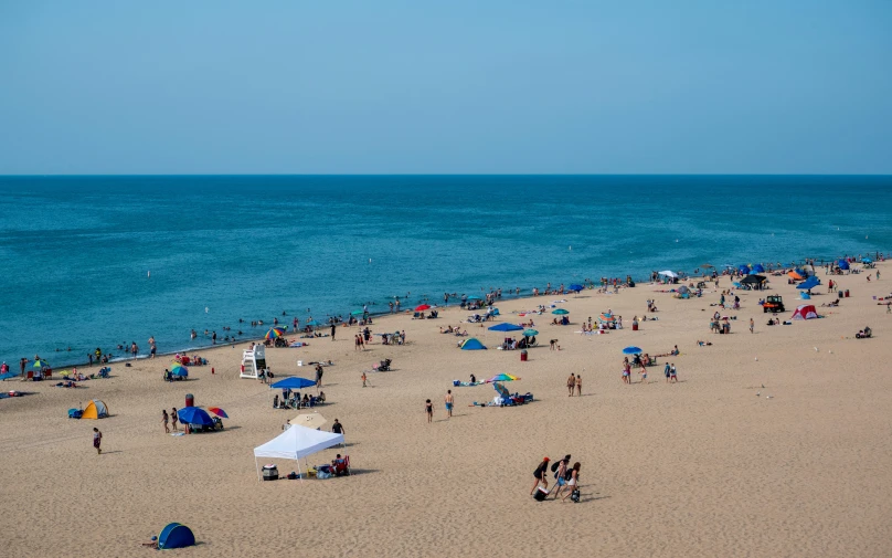 a beach with a crowd of people sitting around it