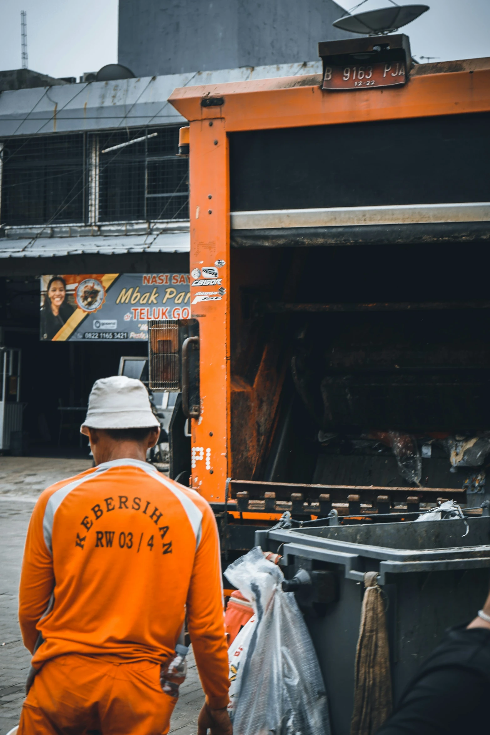 two men in orange vests standing in front of a food truck