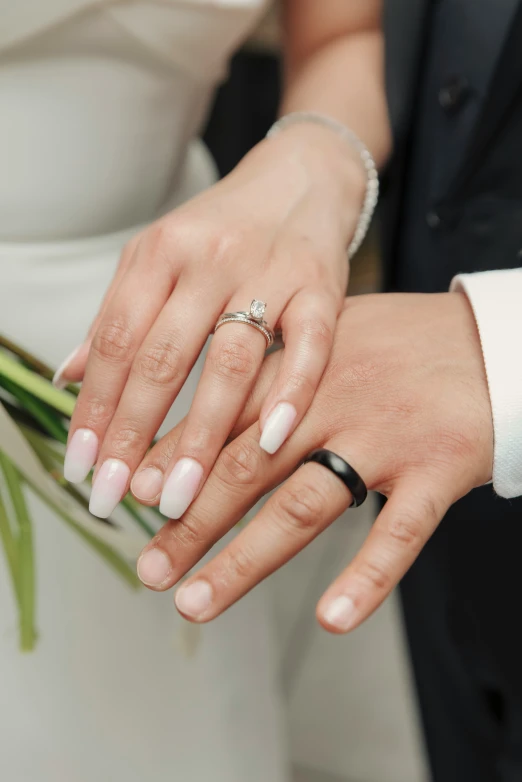 a man and woman's wedding ring being held in their hands