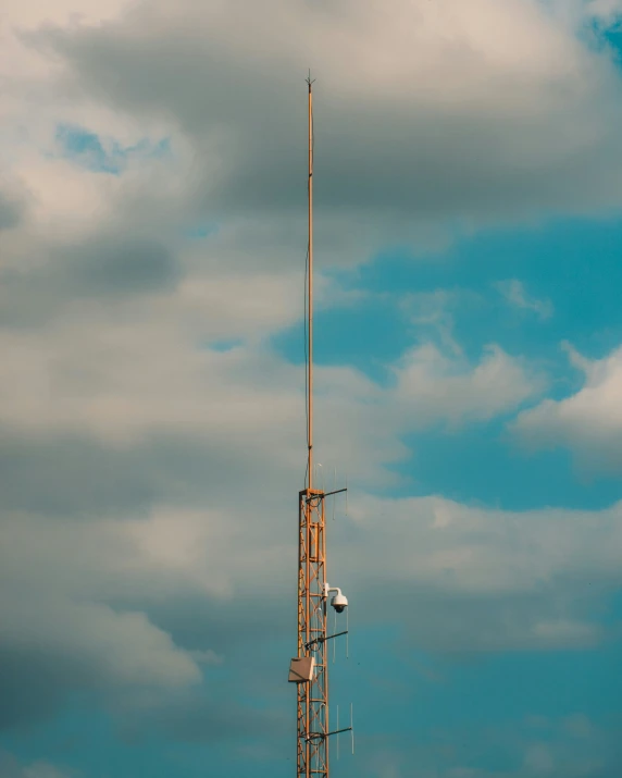 a tall radio tower under cloudy skies