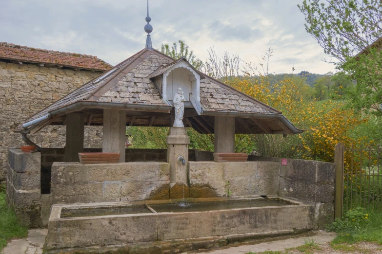 a stone fountain in front of a brick building