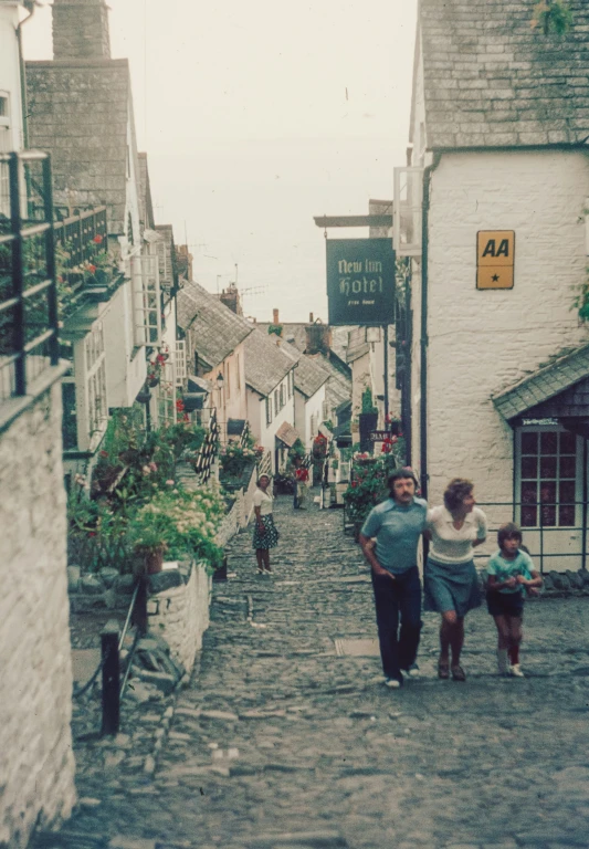 a family of three is walking down a cobblestone street