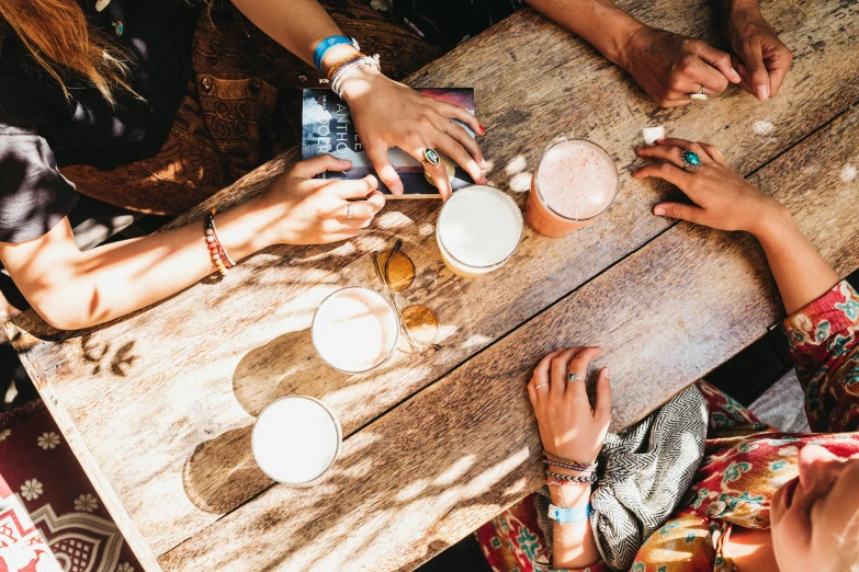 people sit around a table having drinks and a conversation