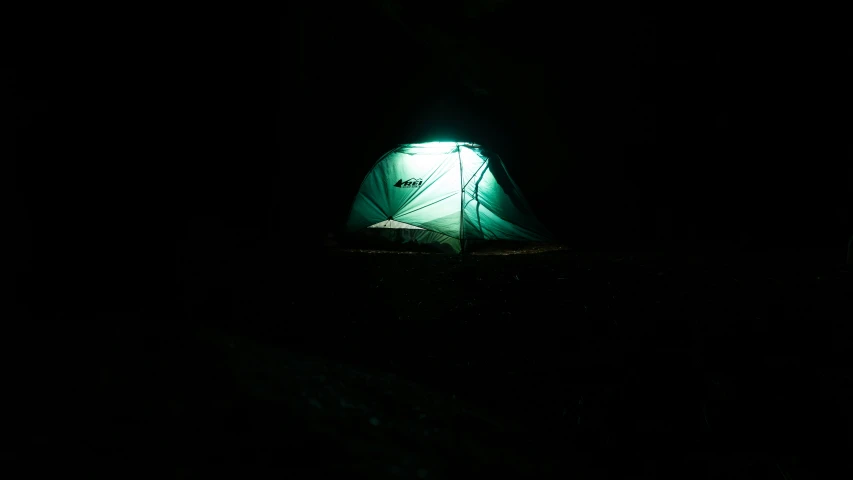 a tent in the dark with a lit up door